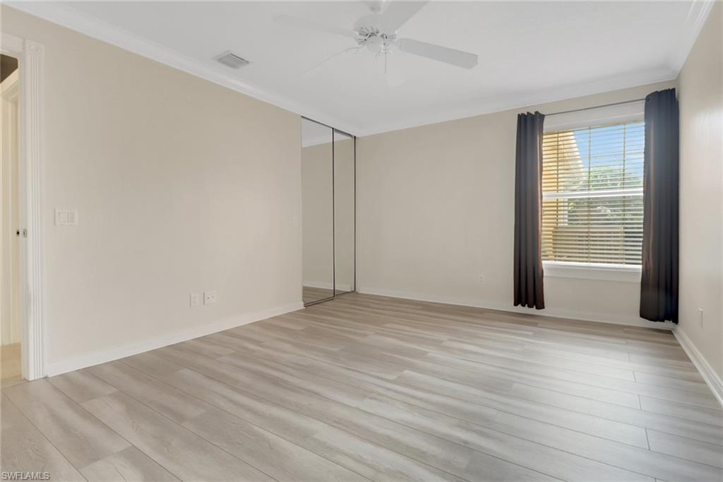 7933 Umberto Court Naples, FL 34114 - Photo 12 of 17 a view of an empty room with wooden floor and a window