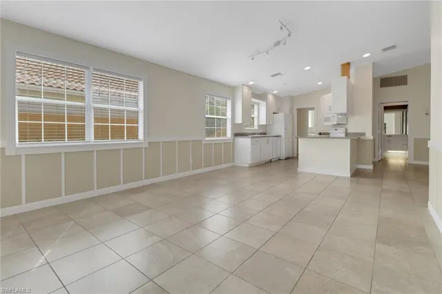 a large white kitchen with a stove a sink dishwasher and a refrigerator with white cabinets