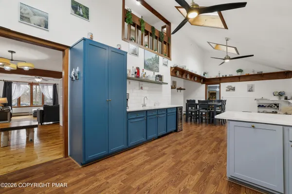 a kitchen with stainless steel appliances a sink a stove a refrigerator cabinets and a dining table