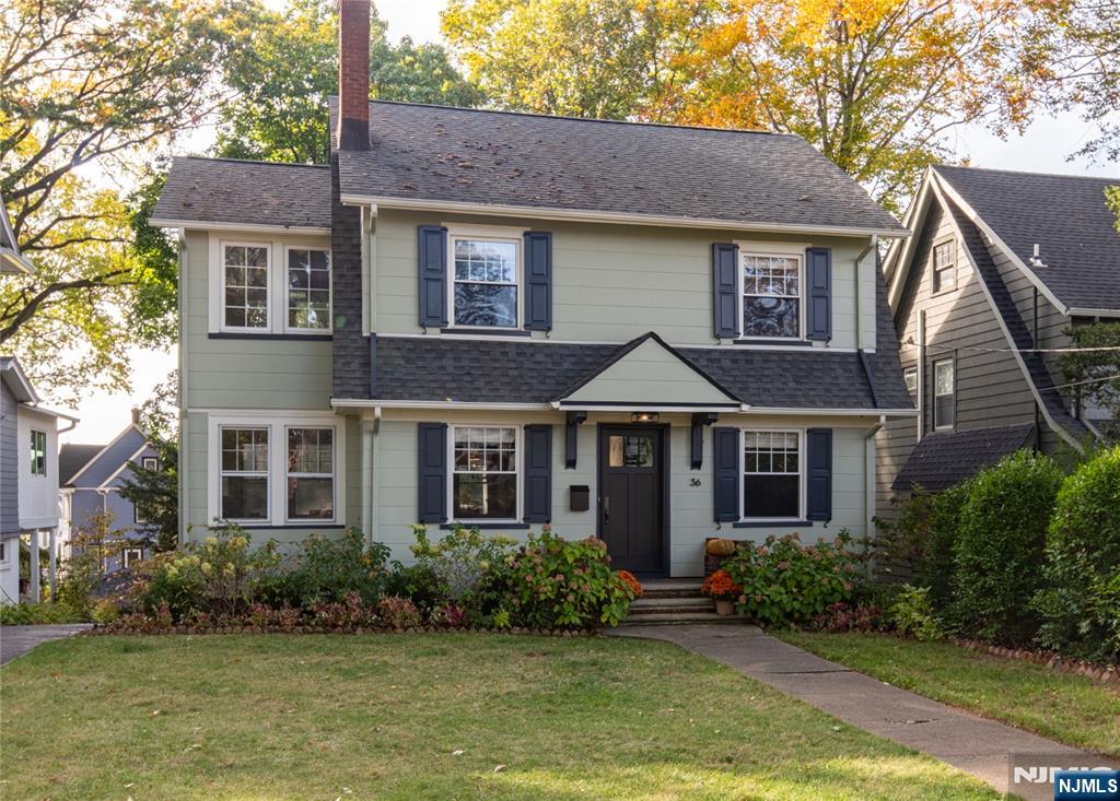 a front view of a house with a yard and potted plants