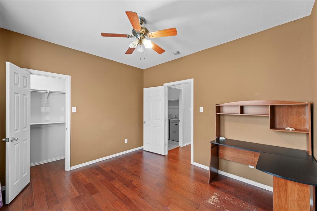 2405 Reston Drive McKinney, TX 75072 - Photo 16 of 38 Unfurnished bedroom featuring a walk in closet, an office area, a ceiling fan, and dark wood-style flooring
