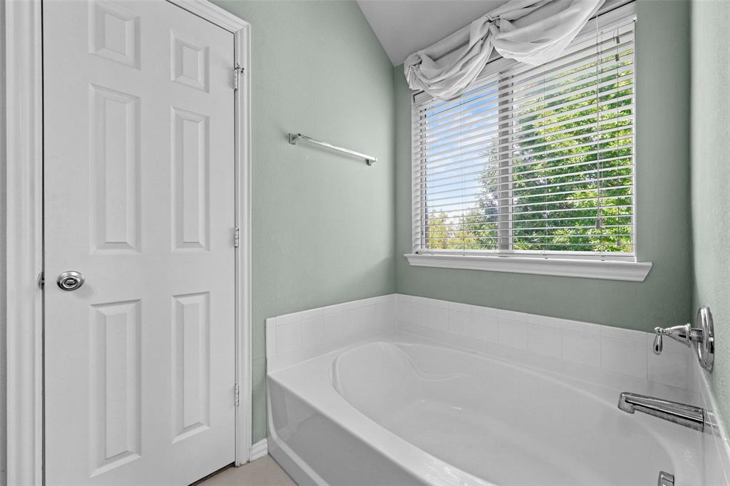 2405 Reston Drive McKinney, TX 75072 - Photo 28 of 38 Bathroom featuring a garden tub and vaulted ceiling
