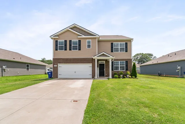 a front view of a house with a yard and garage