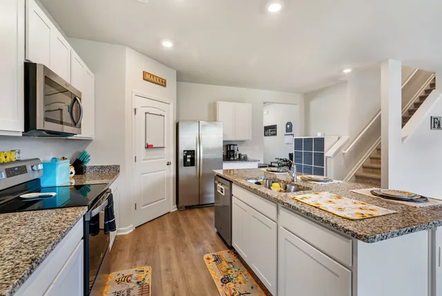 a kitchen with granite countertop lots of counter top space a sink appliances and cabinets