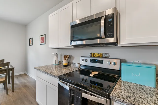 a view of a dining room with furniture a kitchen and wooden floor