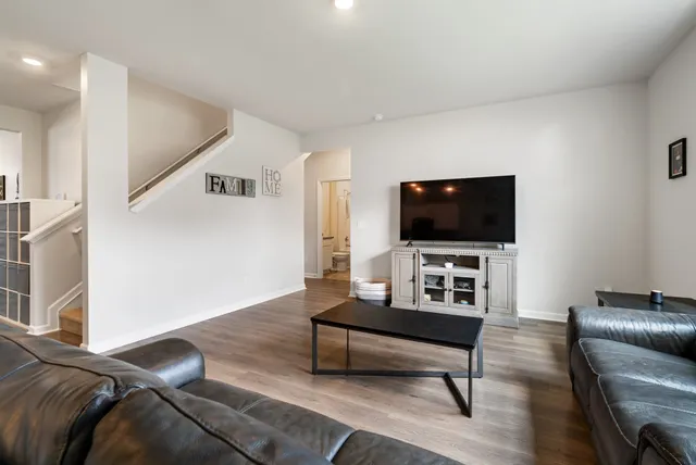 a living room with furniture and a wooden floor