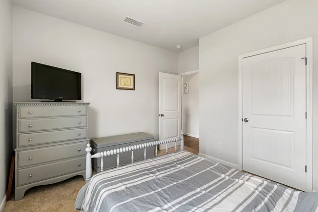 a bedroom with a bed and a large mirror