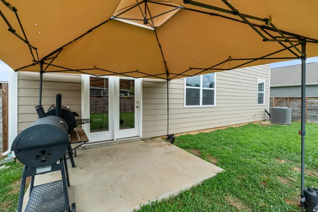 a front view of a house with a yard and potted plants