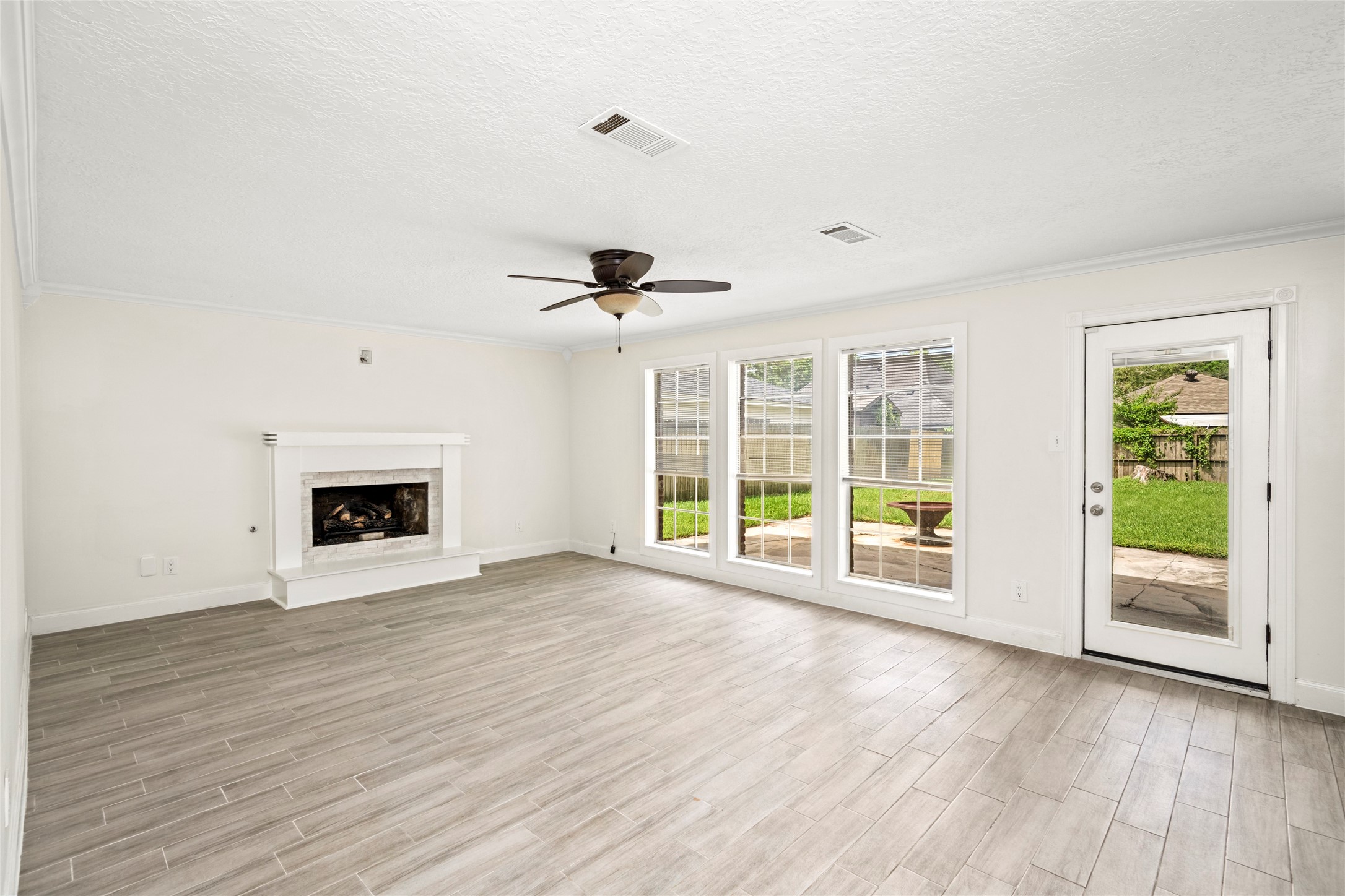 560 Landfall Lane Conroe, TX 77302 - Photo 14 of 41 Spacious family room with gas log fireplace, large windows, and access to the backyard patio.