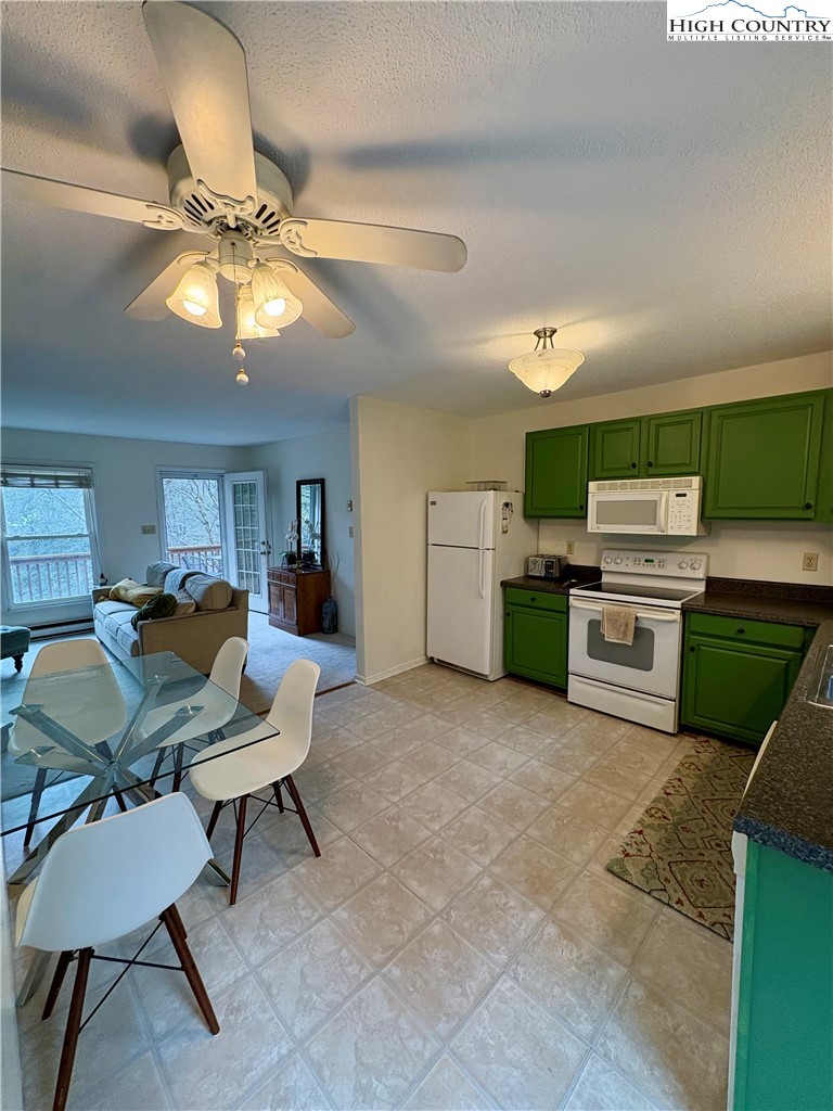 5416 Bamboo Road Boone, NC 28607 - Photo 6 of 35 a kitchen with stainless steel appliances a stove a chimney a dining table and chairs