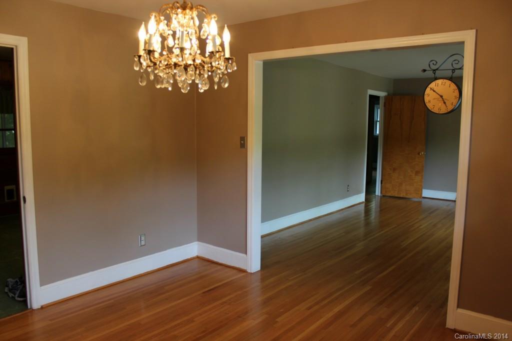 1510 Burnley Road Charlotte, NC 28210 - Photo 5 of 19 an empty room with wooden floor chandelier and closet