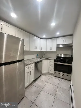 a kitchen with a refrigerator sink and cabinets
