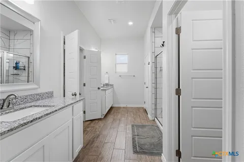a bathroom with a granite countertop sink a mirror and a shower