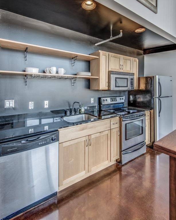 1400 Rosa L Parks Boulevard, Unit 323 Nashville, TN 37208 - Photo 15 of 25 a kitchen with stainless steel appliances granite countertop a sink a stove and cabinets