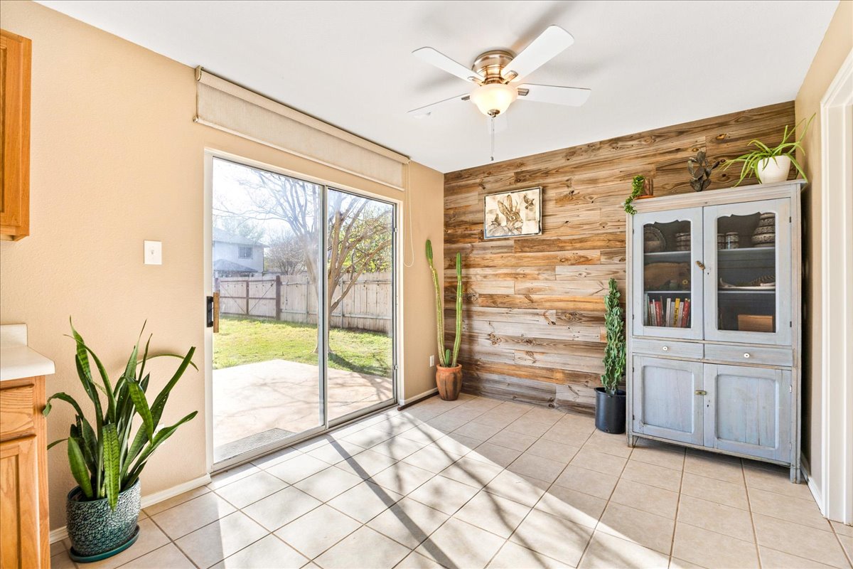 116 Devon's Cove Buda, TX 78610 - Photo 21 of 38 Unfurnished dining area featuring wooden walls, a ceiling fan, and light tile patterned flooring