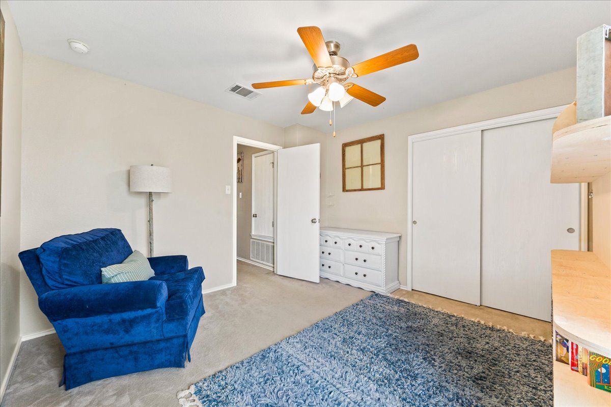116 Devon's Cove Buda, TX 78610 - Photo 10 of 38 Living area featuring light carpet and a ceiling fan