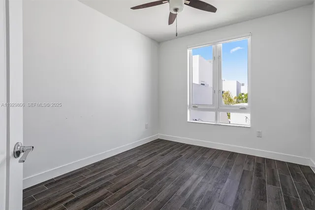 a view of empty room with wooden floor