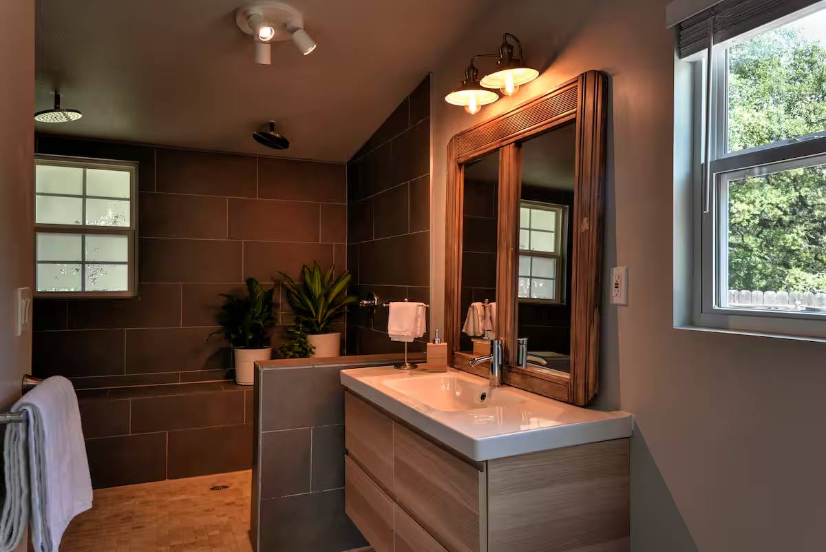 8807 High Valley Road Austin, TX 78737 - Photo 14 of 22 Modern bathroom featuring dual showerheads, a floating vanity, and a window for natural light.