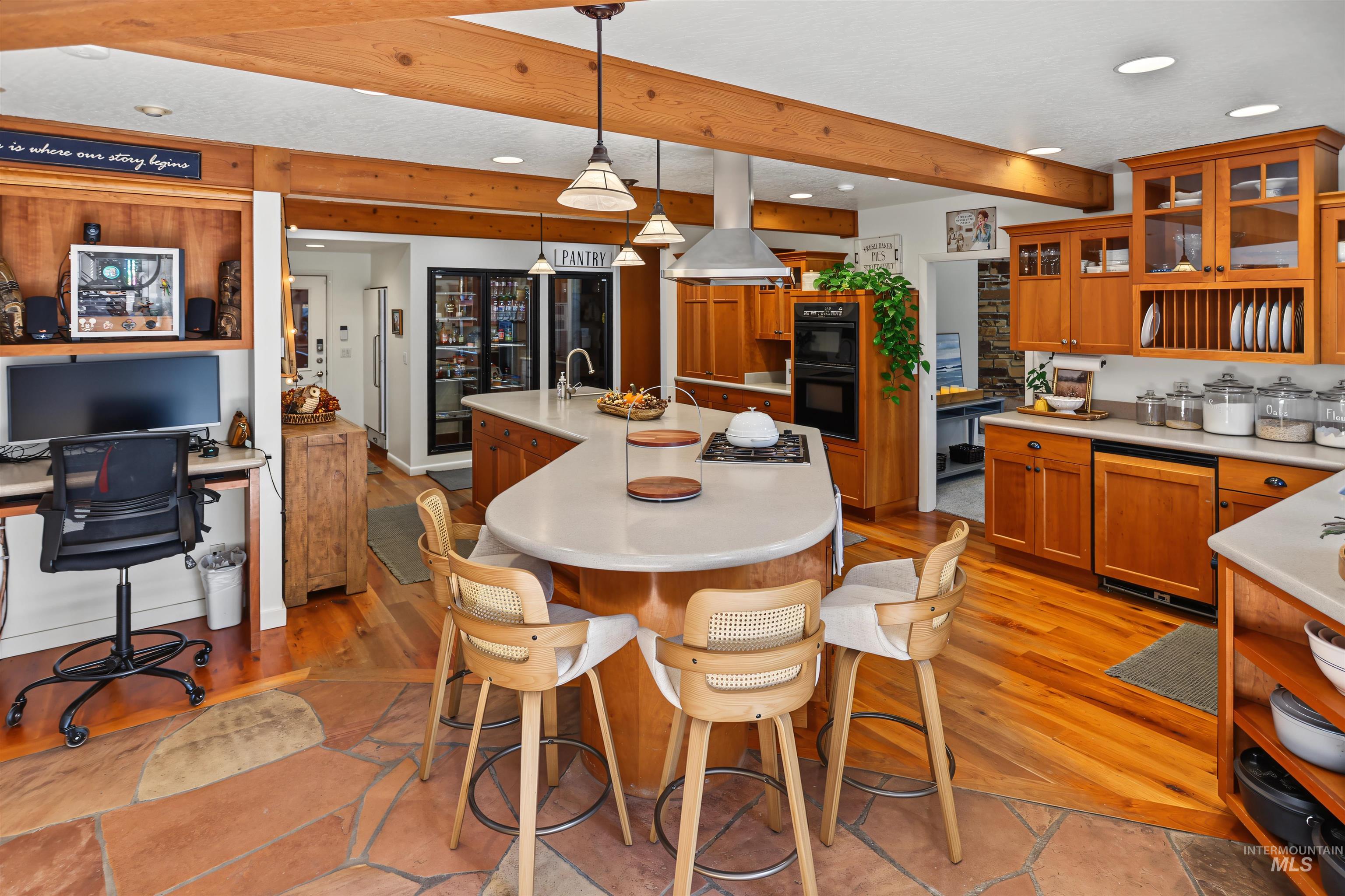 508 East Elm Avenue Parma, ID 83660 - Photo 11 of 50 Kitchen featuring wood cabinetry, stainless steel appliances, a center island with bar seating, and exposed wood ceiling beams
