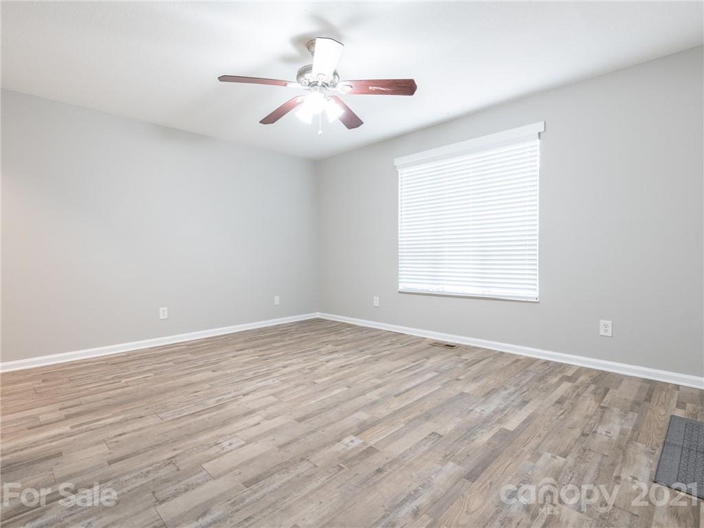 5344 Rockwood Road Charlotte, NC 28216 - Photo 2 of 31 an empty room with wooden floor fan and windows