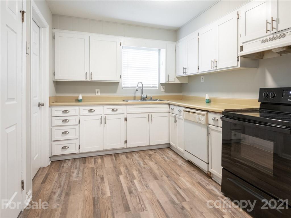 5344 Rockwood Road Charlotte, NC 28216 - Photo 3 of 31 a kitchen with white cabinets stainless steel appliances and sink