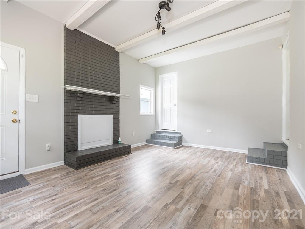 5344 Rockwood Road Charlotte, NC 28216 - Photo 6 of 31 a view of empty room with wooden floor and fireplace