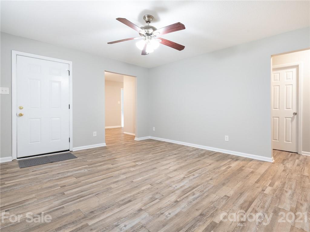 5344 Rockwood Road Charlotte, NC 28216 - Photo 10 of 31 an empty room with wooden floor and ceiling fan