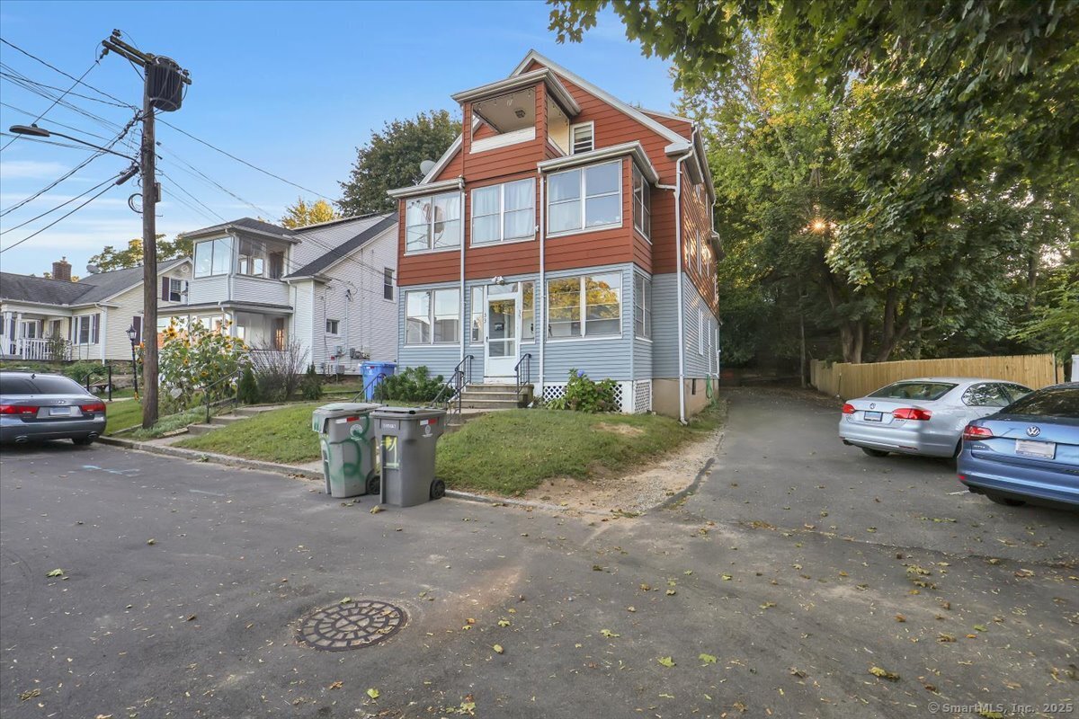 a view of a blue house with a yard and lawn chairs
