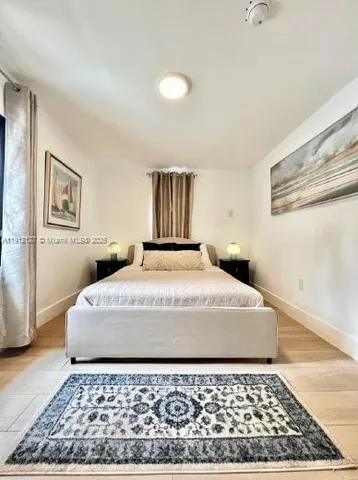 a large bed sitting in a bedroom next to a window