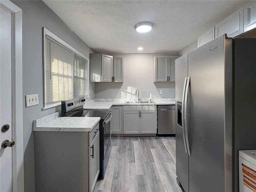 2955 Wanda Circle Southwest Atlanta, GA 30315 - Photo 5 of 10 a kitchen with a refrigerator sink and cabinets