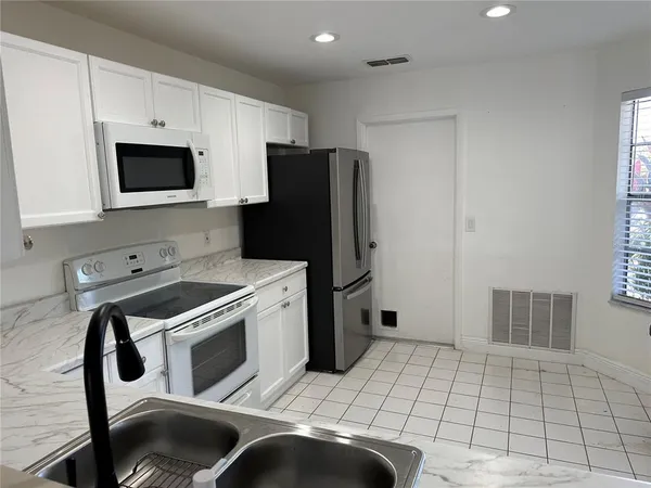 a kitchen with stainless steel appliances a stove a microwave and a refrigerator