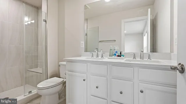 a bathroom with a sink a toilet and a mirror