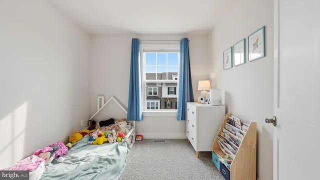 a bedroom with baby crib lounge chair and front door