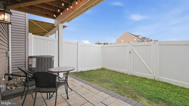 a view of a patio with table and chairs with wooden floor and fence