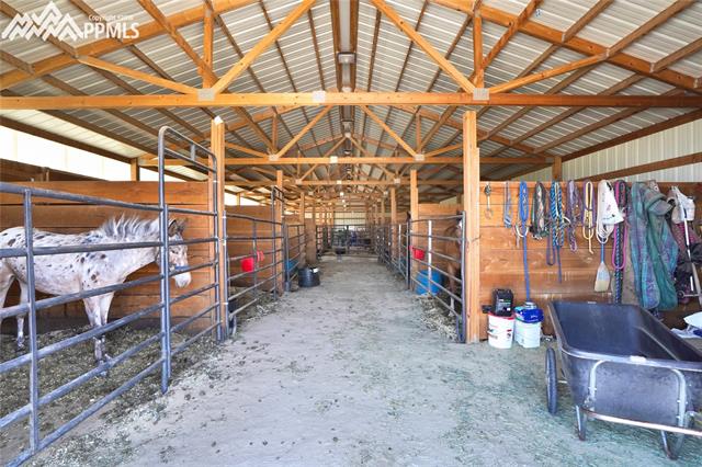 9990 North Log Road Calhan, CO 80808 - Photo 6 of 29 15 stall barn with 1 stall used as hay storage now and another as the tack area.