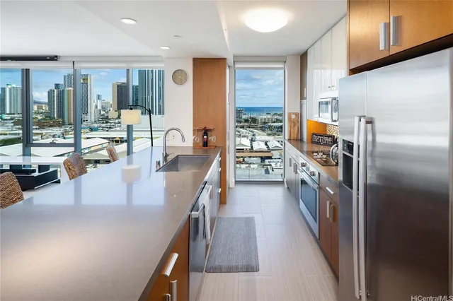 a kitchen with stainless steel appliances granite countertop a refrigerator a stove and a sink