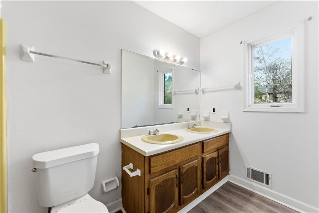 2130 Fieldstone View Court Southeast, Unit B Conyers, GA 30013 - Photo 17 of 18 a bathroom with a granite countertop sink a toilet and a mirror