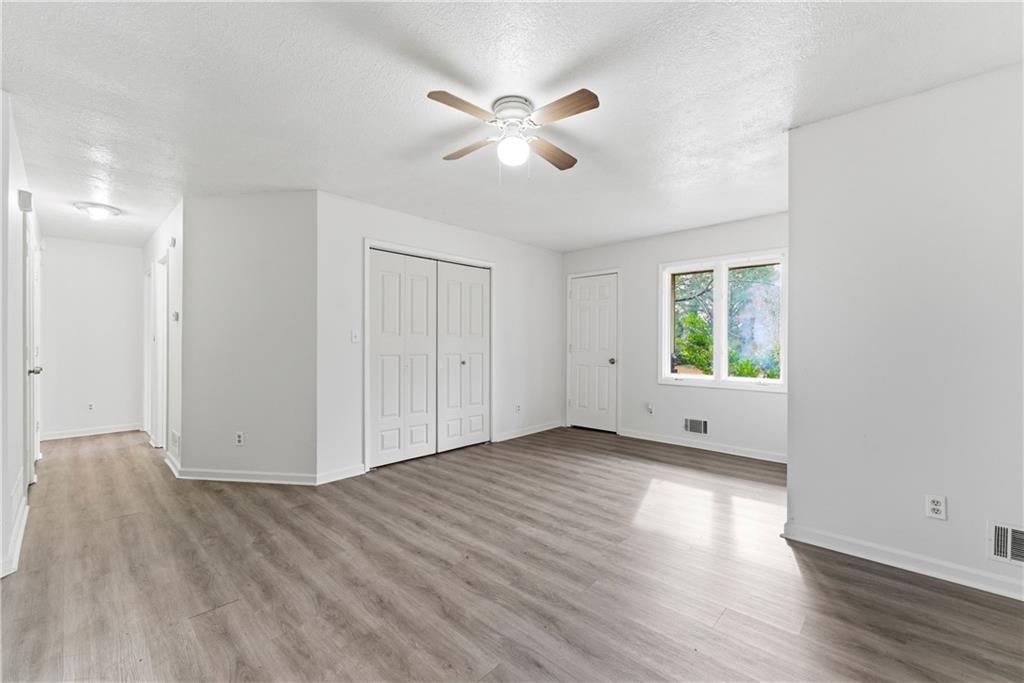 2130 Fieldstone View Court Southeast, Unit B Conyers, GA 30013 - Photo 3 of 18 an empty room with wooden floor and windows