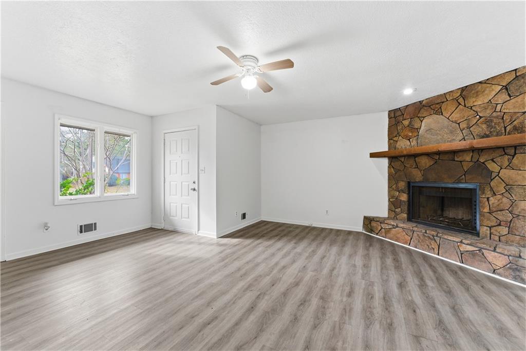 2130 Fieldstone View Court Southeast, Unit B Conyers, GA 30013 - Photo 4 of 18 an empty room with windows and fireplace