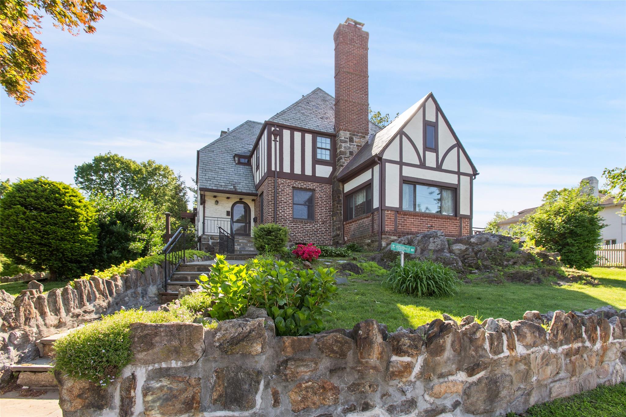 93 Petersville Road New Rochelle, NY 10801 - Photo 1 of 1 Rear view of property with brick siding, a chimney, and a lawn