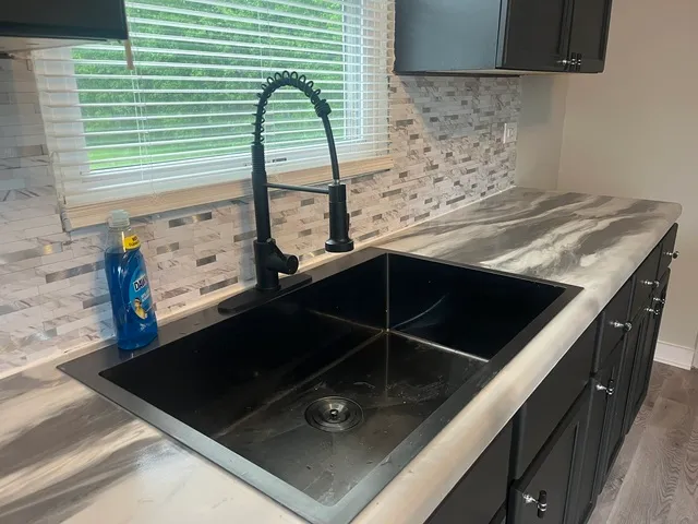 a close view of kitchen sink stove and microwave