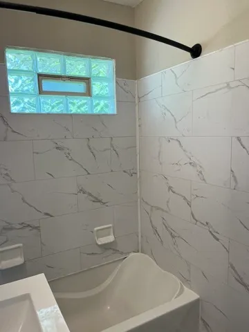 a bath tub sitting next to a white sink and vanity