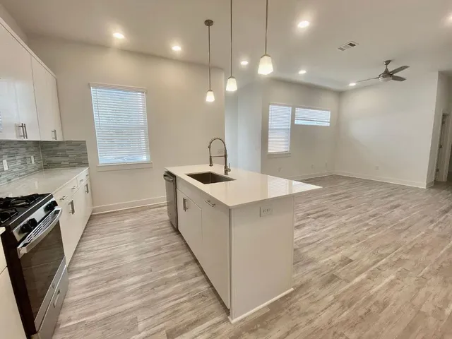 a kitchen with a sink stove and cabinets