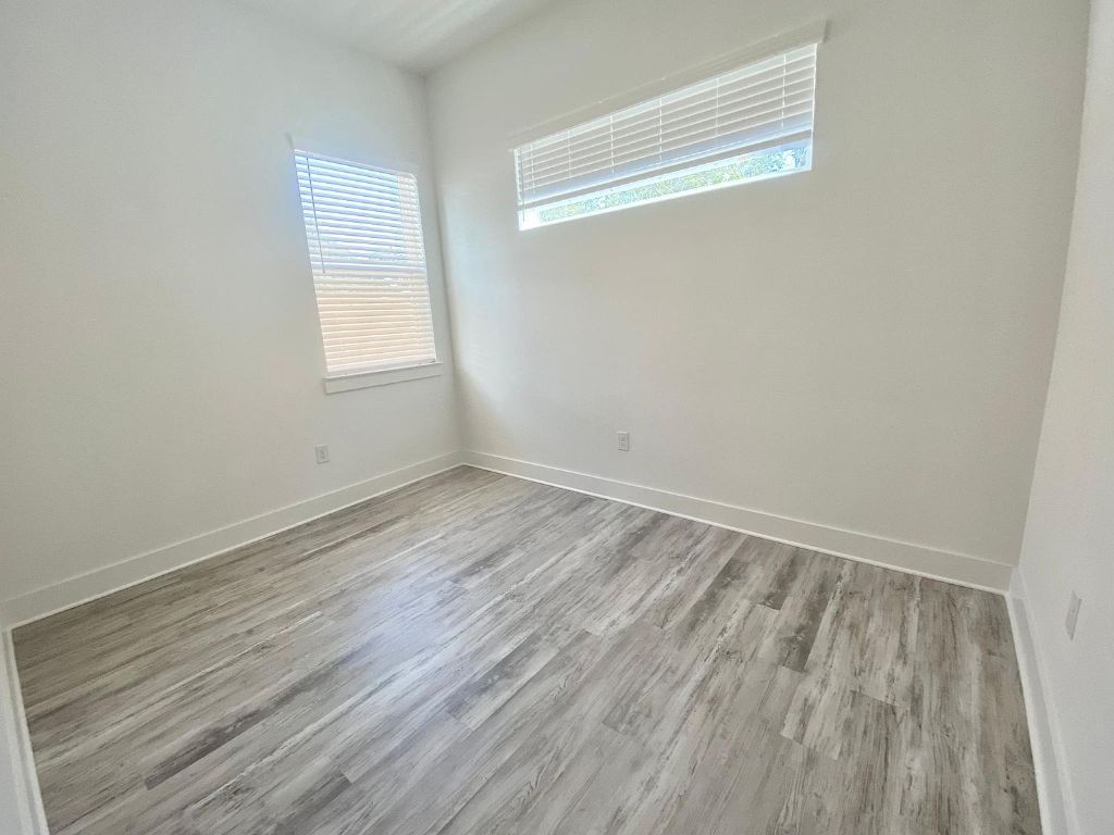6809 Montana Street, Unit 2 Austin, TX 78741 - Photo 10 of 29 an empty room with wooden floor and windows