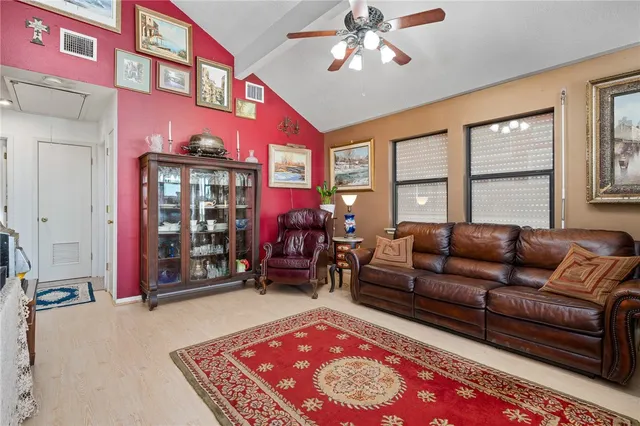 a living room with furniture a chandelier and a rug
