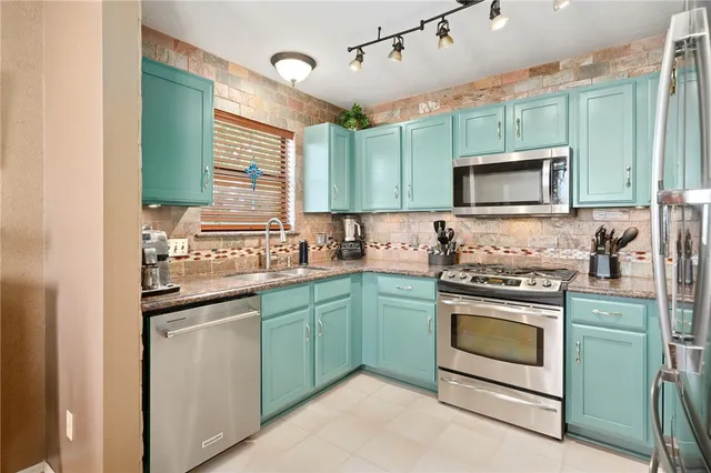 a kitchen with stainless steel appliances granite countertop a stove a sink and a microwave