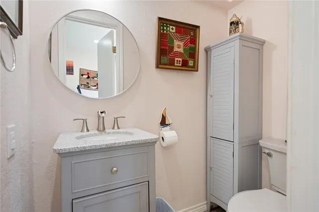 a bathroom with a toilet a sink and mirror