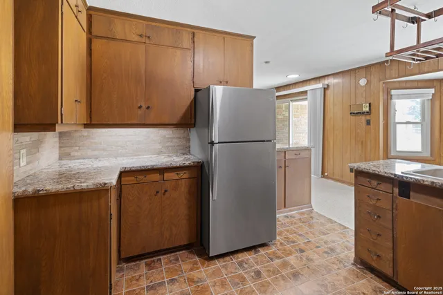 a kitchen with stainless steel appliances granite countertop a refrigerator and a stove