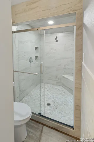 a bathroom with a granite countertop sink a toilet and shower