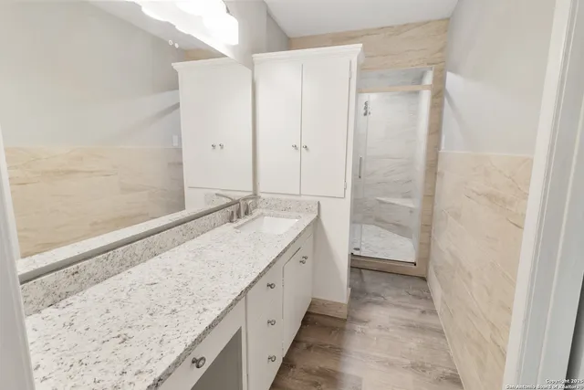 a bathroom with a granite countertop sink and a mirror